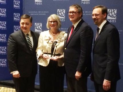Nancy Ayala (BTGMI Spanish Ministries) and BTGMI Director Kurt Selles (Center) receive Milestone Award from NRB president.