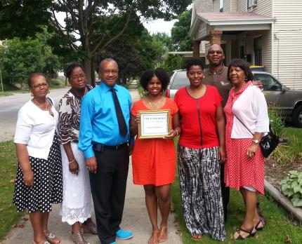 Aikelah Johnson shows off plaque that came with scholarship.