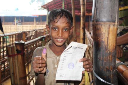 A boy waited in line in the rain to receive emergency supplies from World Renew for his family. His thumb print was used to record receipt of the goods.