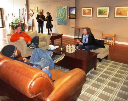 Allen Kleine Deters talks in the background while his wife, Freda, speaks with two church members .