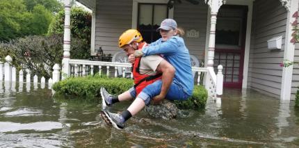 A Texas National Guard soldier carries a woman on his back as they conduct rescue operations in flooded areas around Houston, Texas, U.S., Aug. 27, 2017. 
