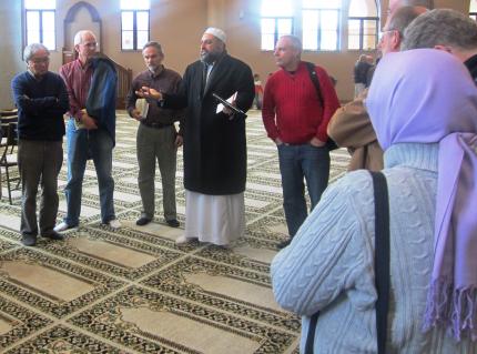 Imam Morsy Salem (center) speaks to group inside mosque.