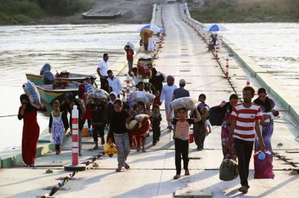 Displaced people from the minority Yazidi sect re-enter Iraq from Syria at a Iraqi-Syrian border crossing.