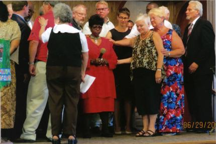 People lay on hands during service at Bethany CRC