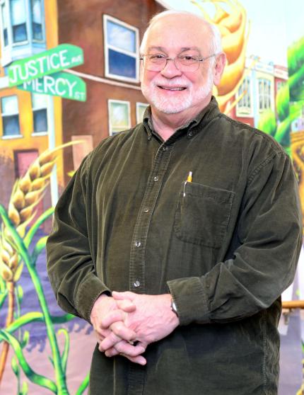 Manny Ortiz stands at the corner of Justice and Mercy streets.