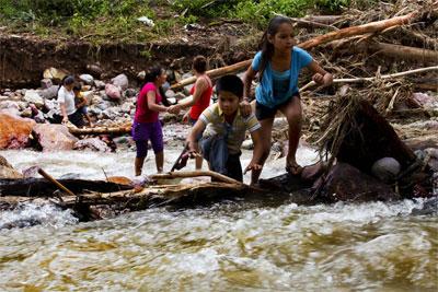 Children cross a river on the mountain range of Zihuatanejo in Guerrero state September 22, 2013.
