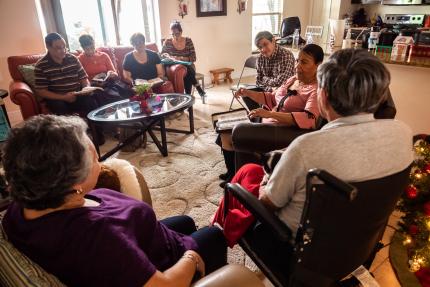 Magda, center/right, with Bible in her lap, speaks to her support group.