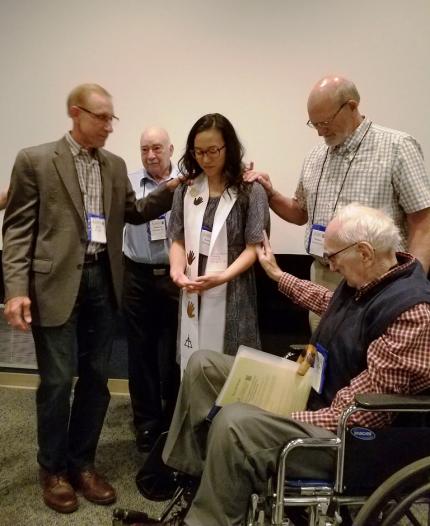 Former chaplaincy office directors (from left) Ron Klimp, Herm Keizer, Seibert VanHouten and Hal Bode pray for Sarah Roelofs.