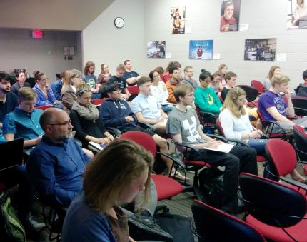 Students and others listen to talk about science and faith.