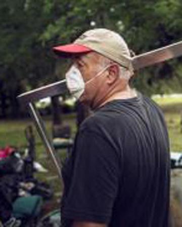 Bill Taylor helps clean and remove debris from the interior of a friend's flood damaged home in San Marcos, Texas.