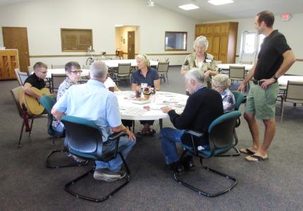 Participants and volunteers for the Wellspring program work on a craft.