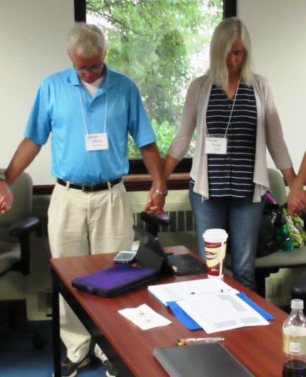Mark Wiersma and his wife, Anne, pray after telling their story.