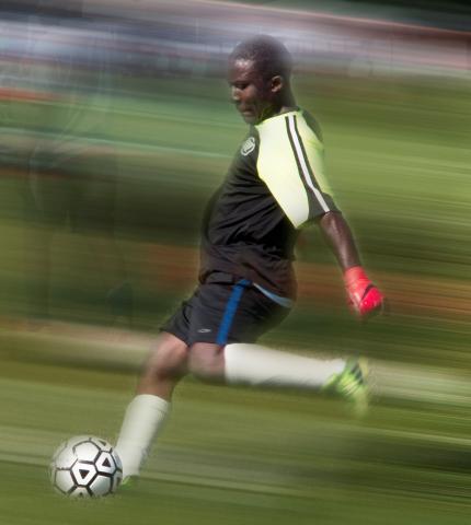 A member of the African team kicks the ball.